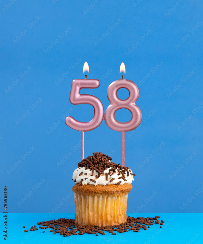 Birthday candle with cupcake on blue background - Number 58
