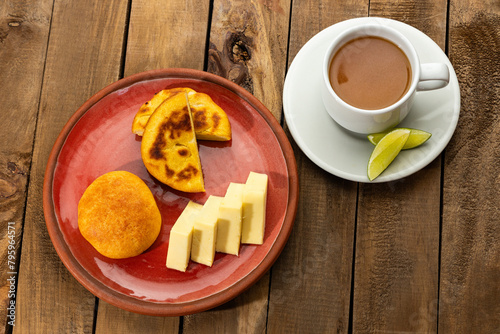 Breakfast served at the table - Arepa, almojabana, cheese and hot aguapanela. Colombian gastronomy photo