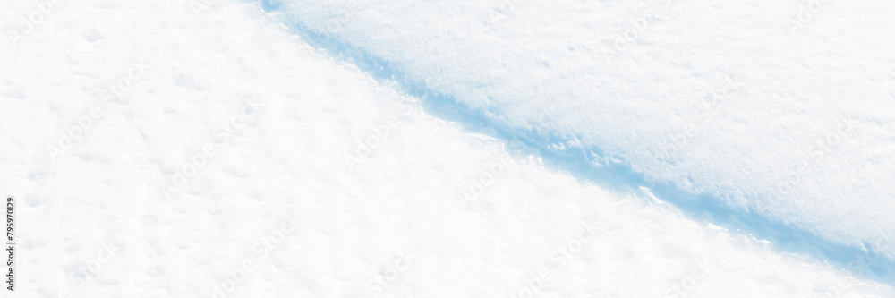 Wide panoramic winter background with snowy ground. Natural snow texture. Wind sculpted patterns on snow surface. Closeup top view with copy space. Wide panoramic winter background with snowy ground. Natural snow texture. Wind sculpted patterns on snow surface. Closeup top view with copy space.