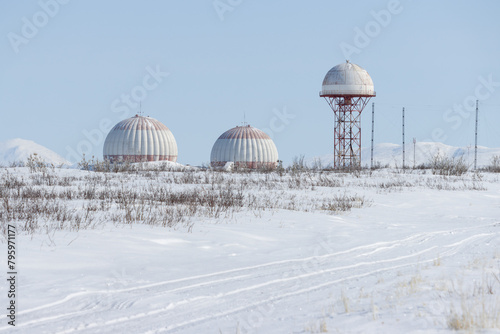 Aeronautical radar in the snowy tundra. Huge locators support aircraft flights. Large domes (radiotransparent shelters) of a radar station.