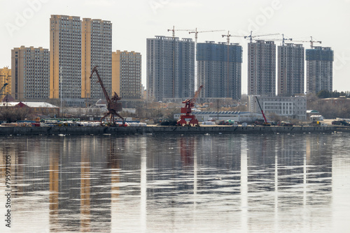Construction of multi-storey residential buildings on the banks of the Amur River. Heihe, China. River port berth. The Chinese city of Heihe is located on the border with Russia.