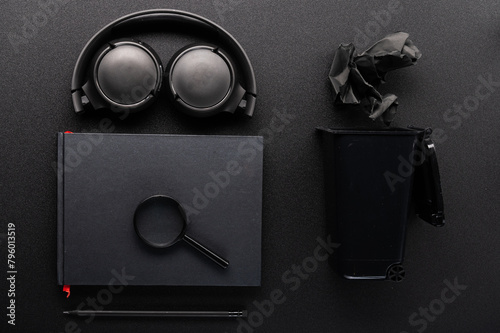 Black stationery on a black table. Black notepad and black pencil. Notes on black paper. Flat lay.