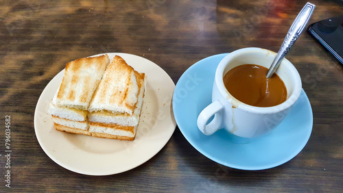 Kaya Toast And Milk Coffee Of Singaporean Breakfast. Kaya Toast Is Toasted Bread Filled With Butter And Kaya, A Jam Made From Eggs, Sugar, Coconut Milk, And Pandan Leaves. photo