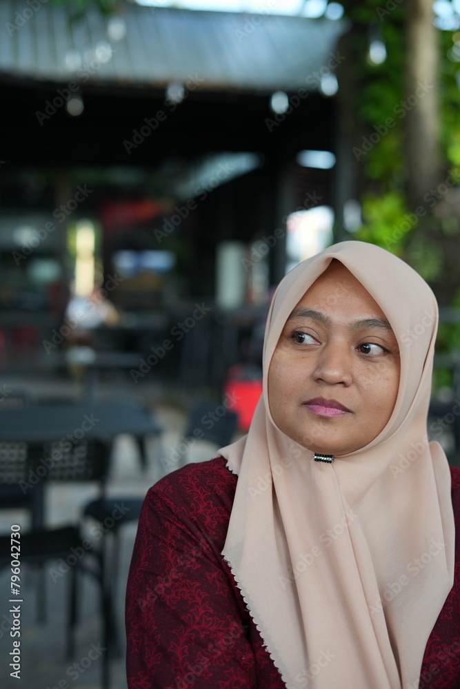 Portrait of a woman wearing a hijab in a cafe