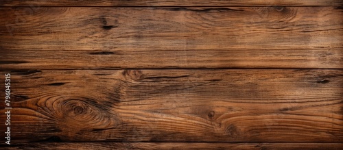 Close up of brown hardwood plank flooring with wood stain on a wooden surface