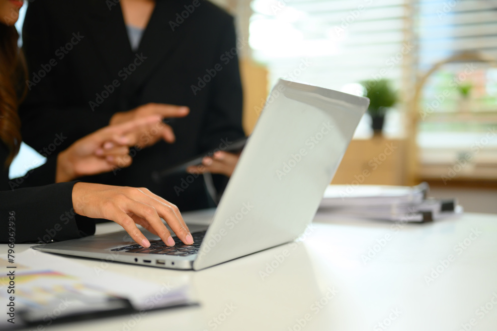 Cropped shot businesspeople using laptop brainstorming over new marketing at office Cropped shot businesspeople using laptop brainstorming over new marketing at office