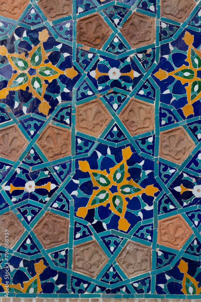 Vertical photo. Close up of fragment of blue-yellow geometric pattern of wall of Motley Bath in Tbilisi with flower, star. Mandala. Georgia. Concept of architecture, real estate agency, rent apartment