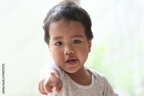 An Asian babby boy points at the camera photo