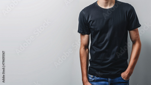 Mockup of clothes worn by a model. Close up of full upper body part from hip to neck on plain background. A man wearing a basic black t-shirt on a plain light grey background. photo