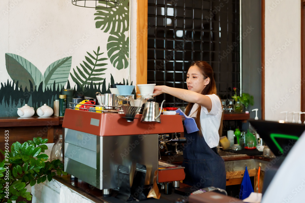 Asian beautiful woman Wiping down cup of coffee behind bar counter in cafe And prepare to open cafe in morning of every day. to be ready to accept customers. coffee shop owner Family small business.. Asian beautiful woman Wiping down cup of coffee behind bar counter in cafe And prepare to open cafe in morning of every day. to be ready to accept customers. coffee shop owner Family small business..
