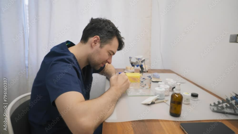 Professional dentistry specialist making artificial teeth models at a lab. Professional dentistry specialist producing restorations. Professional dentistry specialist manufactures tooth crowns. Professional dentistry specialist making artificial teeth models at a lab. Professional dentistry specialist producing restorations. Professional dentistry specialist manufactures tooth crowns.