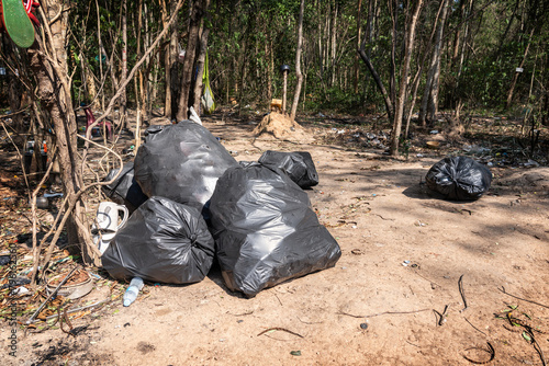 Pile of garbage in black bags in junkyard in the forest or empty area from the city provinces of Thailand.