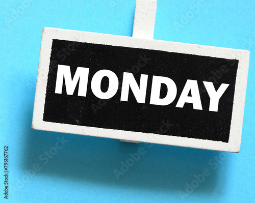 The word MONDAY on a small chalk board over a blue background.
