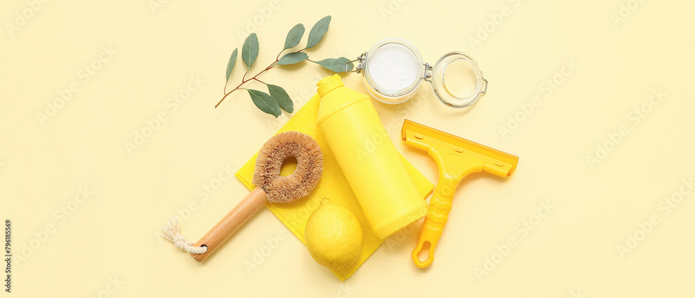Soda with lemon, bottle of detergent and cleaning supplies on light yellow background Soda with lemon, bottle of detergent and cleaning supplies on light yellow background