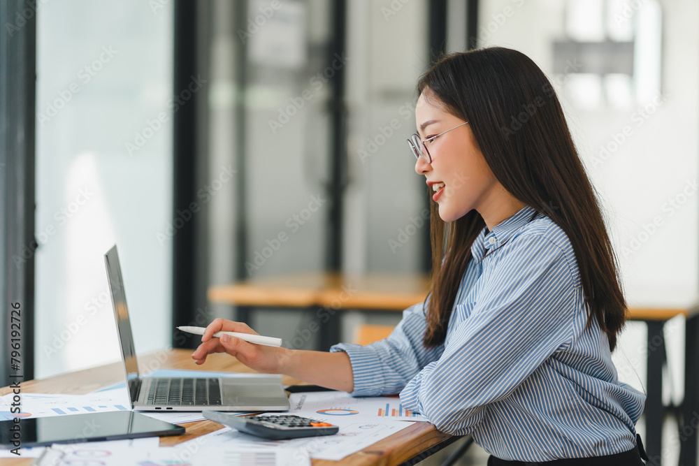 Concentrated asian business woman working with laptop at modern office. Concentrated asian business woman working with laptop at modern office.