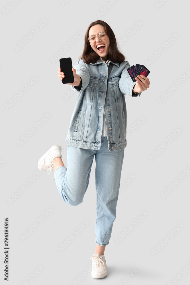 Young woman with credit cards and mobile phone on white background. Online shopping Young woman with credit cards and mobile phone on white background. Online shopping