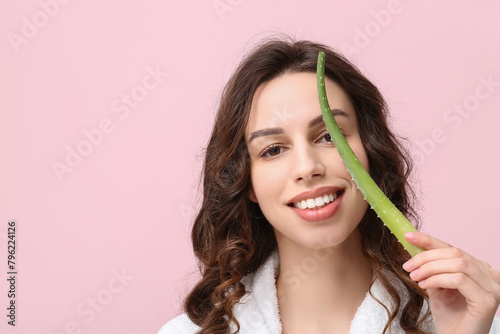 Beautiful young woman with aloe vera on pink background photo