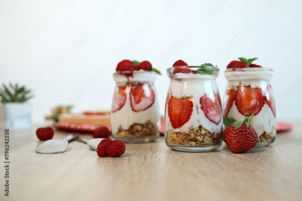 Fresh Organic Strawberry Parfait Jars on Wooden Table. Healthy Breakfast of Strawberry Parfaits Made With Fresh Fruit, Yogurt and Granola. Fresh Organic Strawberry Parfait Jars on Wooden Table. Healthy Breakfast of Strawberry Parfaits Made With Fresh Fruit, Yogurt and Granola.