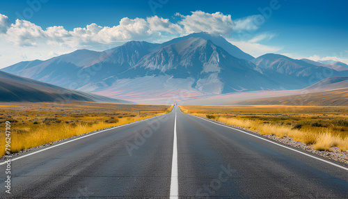 asphalt road on the prairie goes beyond the horizon to the high mountains photo