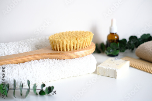 Massage wooden body brush on the background of spa items. Homemade body care. Dry lymphatic drainage massage and spa treatments.