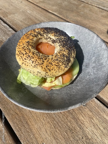salmon bagel on a plate on a wooden floor 