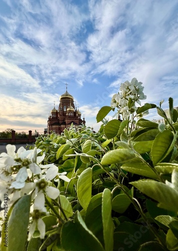 beautiful Orthodox church on the background of spring blooming flowers