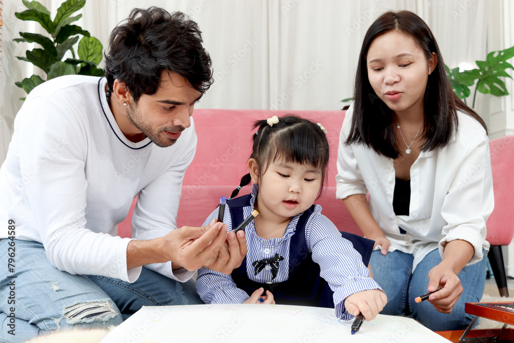 Happy Asian family. Chubby little girl daughter drawing together with father and mother in living room. Parents spend time with toddler kid at home. Child, mom and dad playing together in house. Happy Asian family. Chubby little girl daughter drawing together with father and mother in living room. Parents spend time with toddler kid at home. Child, mom and dad playing together in house.