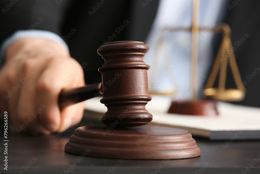 Male judge with gavel at table in courtroom Male judge with gavel at table in courtroom