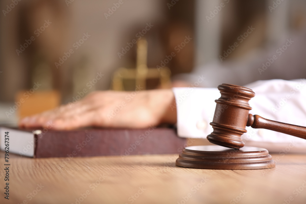 Judge's gavel on table against male lawyer with law book in office Judge's gavel on table against male lawyer with law book in office
