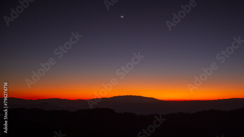 Sunset or evening time over the mountain with small half moon.