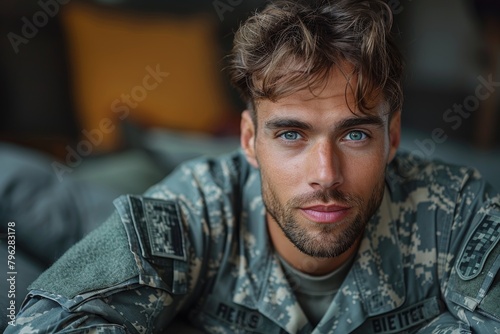 A young and attractive soldier in camouflage attire looks on with striking blue eyes and a soft expression