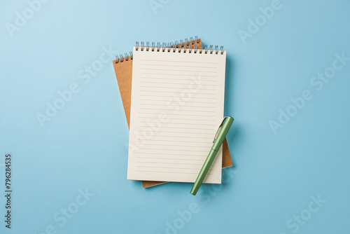 Top view of notebook and fountain pen on blue background © yalcinsonat