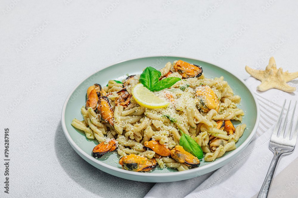 Plant based pasta with mussels, pesto and parmesan cheese. Ready to eat healthy food, served portion Plant based pasta with mussels, pesto and parmesan cheese. Ready to eat healthy food, served portion