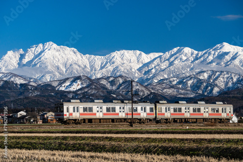 剱岳を眺めながら走る富山地方鉄道の電車