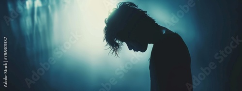 A blurred silhouette of a person with their head hanging low, conveying the emotional toll of addiction.