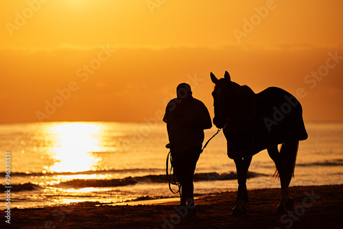 Rider exercises horse in the sea at sunrise © Nicole Ciscato