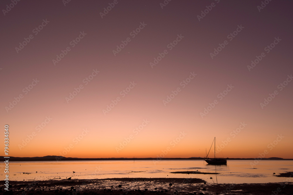 boat on water, silhouette at dusk sunset, purple orange tones, copy space, clear sky, warm coastal beach weekend lifestyle, relaxation boat on water, silhouette at dusk sunset, purple orange tones, copy space, clear sky, warm coastal beach weekend lifestyle, relaxation