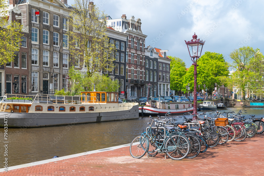 Fototapeta premium Bicycles next to a canal in Amsterdam, the Netherlands on a sunny day
