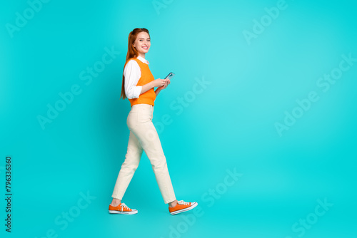 Profile photo of charming lovely woman wear trendy orange clothes walk empty space isolated on cyan color background