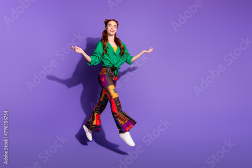 Full size photo of charming woman dressed vintage trousers palms comparing products empty space jump isolated on purple color background © deagreez