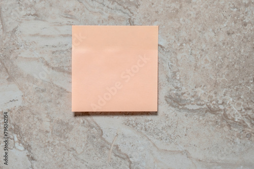 Empty paper sticker on marbled tile wall. Space for your text.