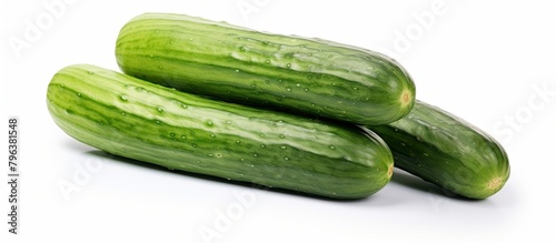 Three cucumbers on white surface with water drops