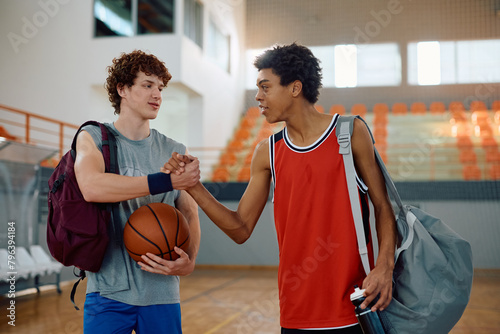 Young basketball players greeting on court. photo