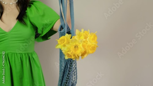 Girl holds bag with bouquet inside, for event planners, emphasizing attention to detail and care for guests, including venue decoration and flower provision. photo