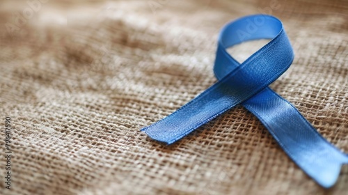 Blue ribbon pinned on a lapel raising awareness for autoimmune and autoinflammatory diseases on World Autoimmune Arthritis Day photo