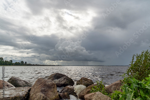 The strong wind and bad weather cause foam between the boulders in the water of the Wolderwijd near Harderwijk, Netherlands