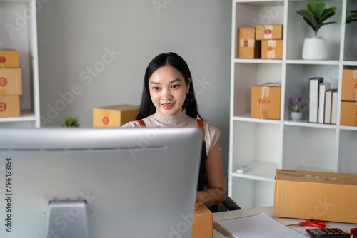 Young business woman asian working online ecommerce shopping at her shop. Young woman sell prepare parcel box of product for deliver to customer. Online selling