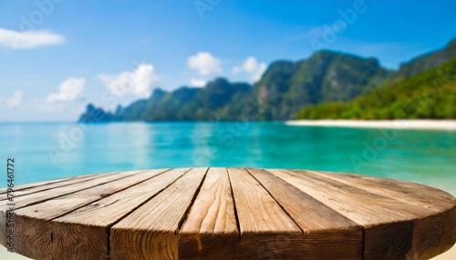 empty round wood table with summer blue sea blur background copy space for display of product on online media © Diann