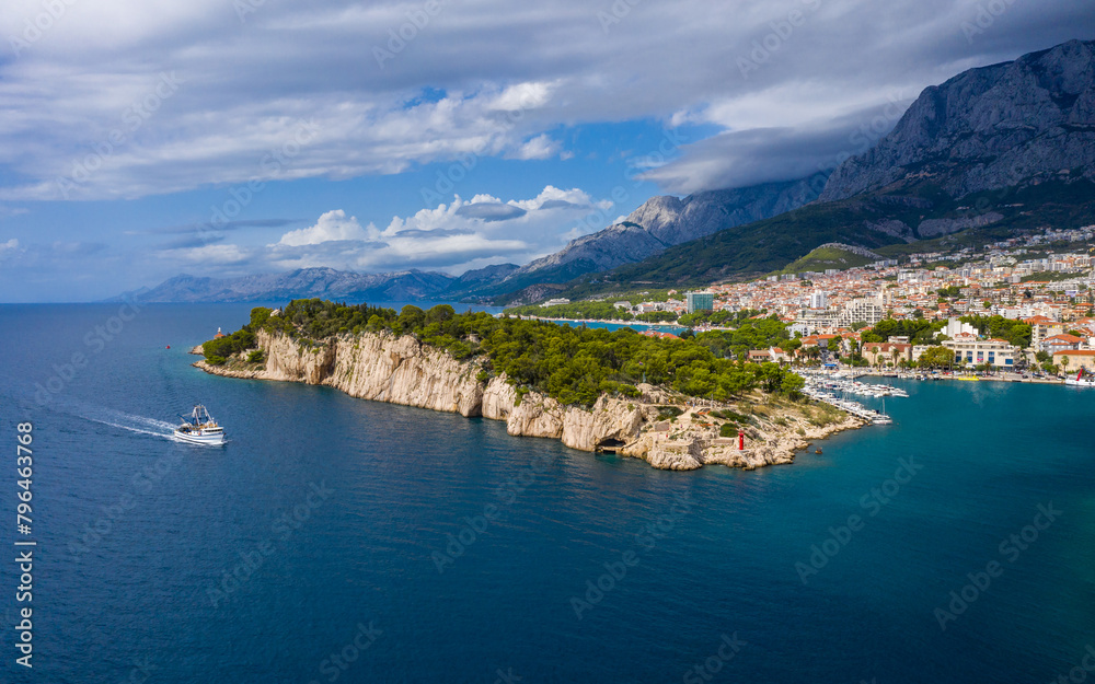 Aerial drone view . Beautiful coastline, white pier going into the sea, blue sea. Makarska is a famous tourist destination in Europe. Croatia Aerial drone view . Beautiful coastline, white pier going into the sea, blue sea. Makarska is a famous tourist destination in Europe. Croatia