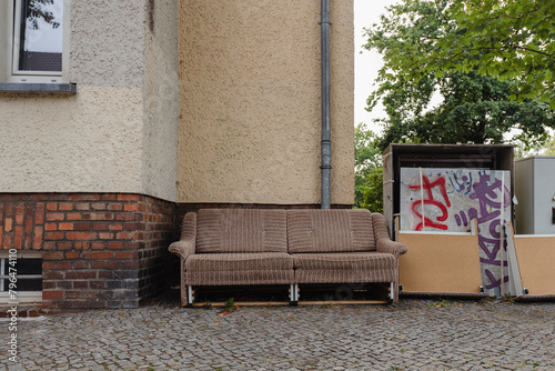 An old couch left on the sidewalk, bulky waste on the street, bulky waste in the city
